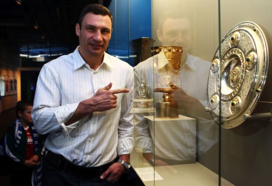 Vitali Klitschko zeigt auf Meisterschale im Schalke-Museum.