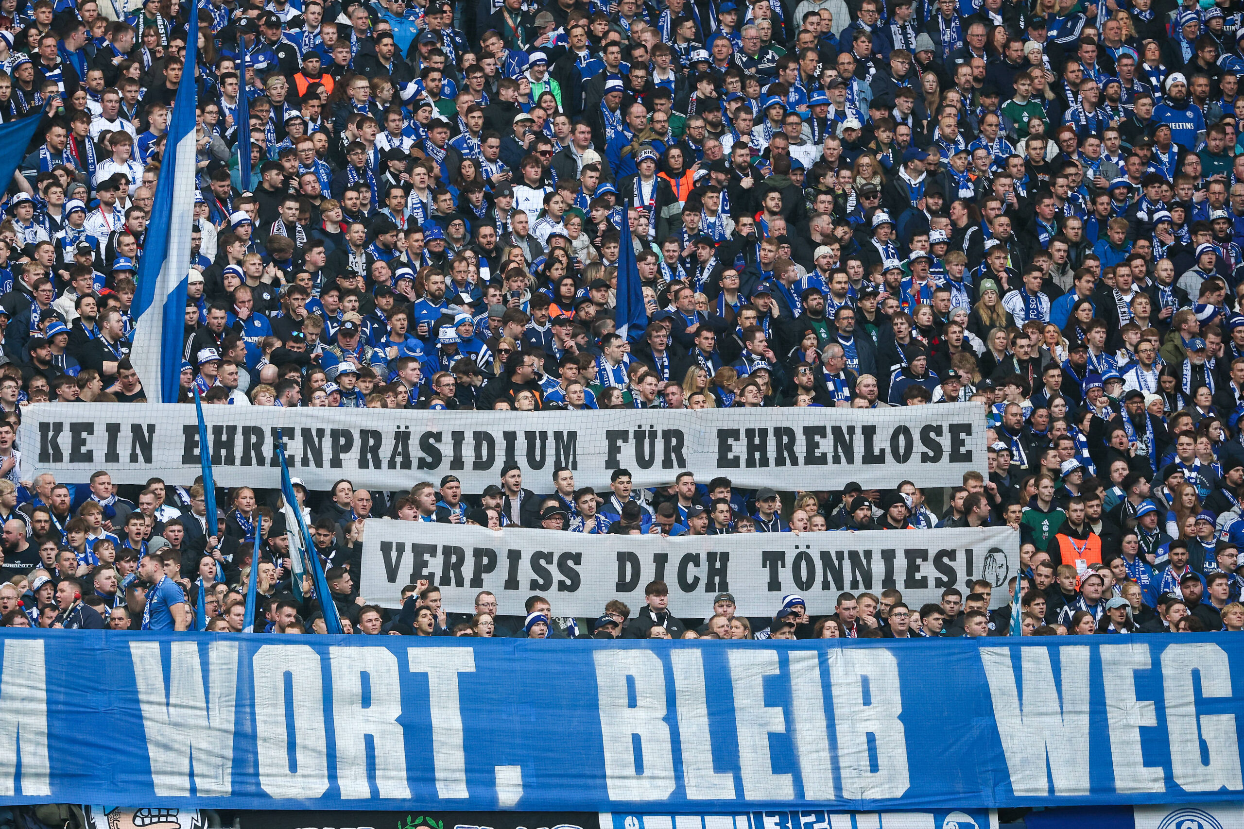 Die Schalke Fans in der Nordkurve mit einem Protest Spruchband / Banner / Transparent gegen Clemens Tönnies